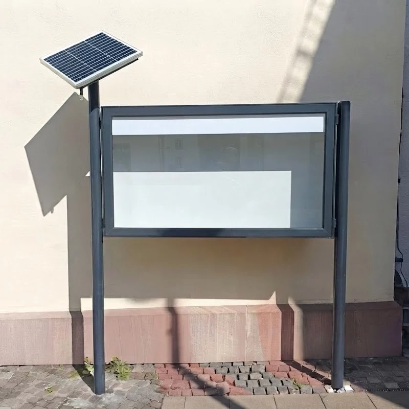 Freistehender Schaukasten mit Solarbeleuchtung Modell VARIO-172 vor einer Hauswand.